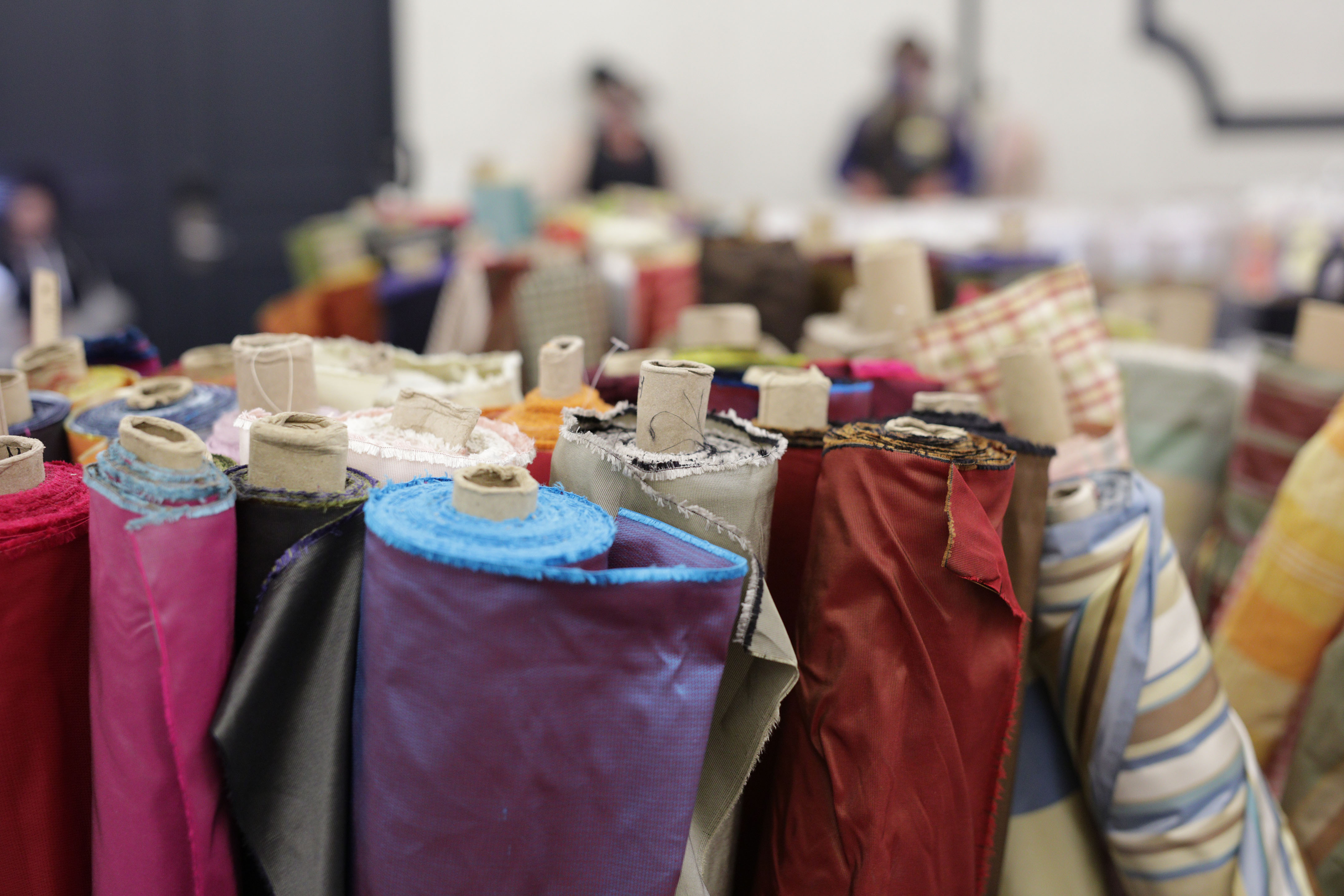 Rolls of fabric in various colors at the Costume College 2024 Marketpalce. Photo by Art Andrews. 